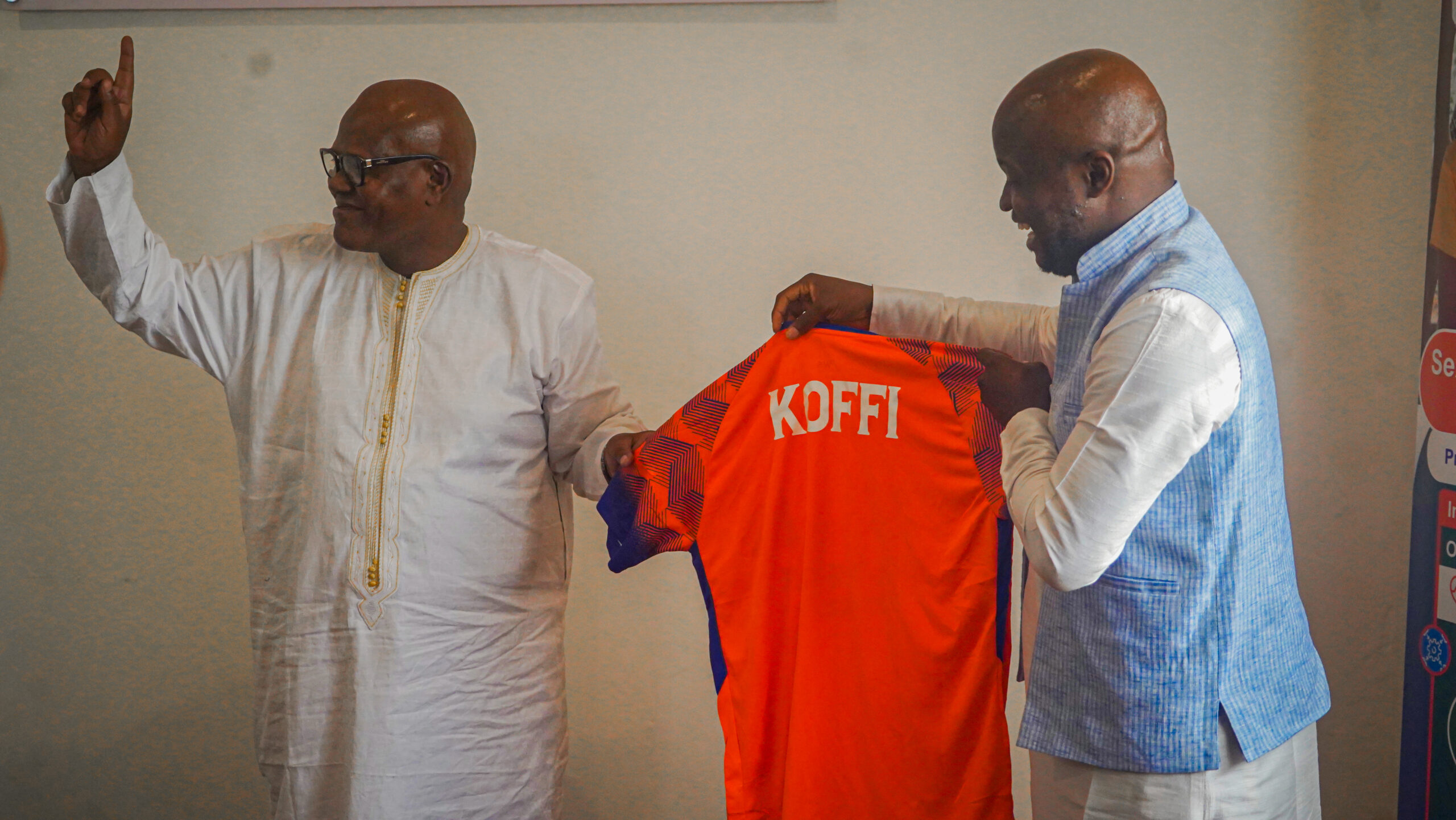 Two men holding a football shirt during LOYOC's visit to UNFPA Cameroon